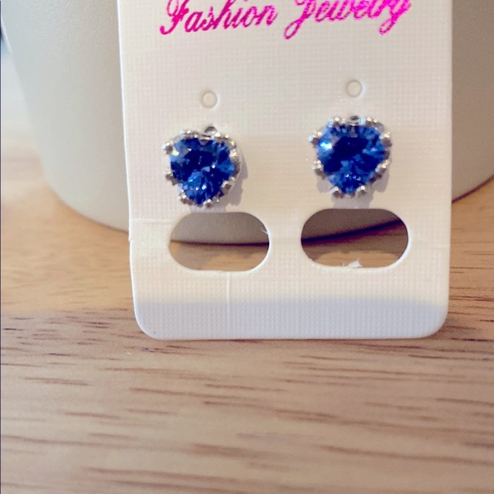 Sterling silver petite heart shaped blue stone earrings.